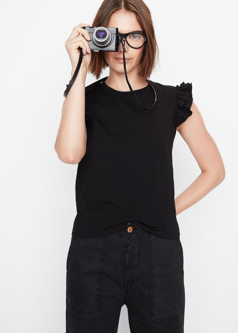 Model wearing the Kiki tee in black with the city pant in black holding an old fashioned camera
