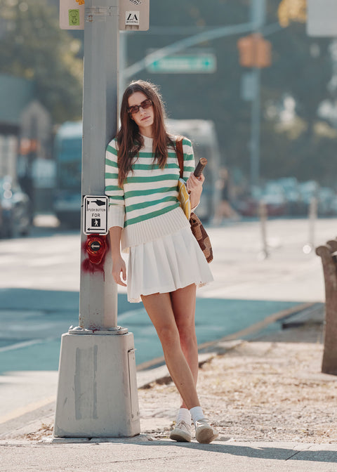 Model on street corner wearing the Tatum in cream/green with the Williams tennis skirt in white