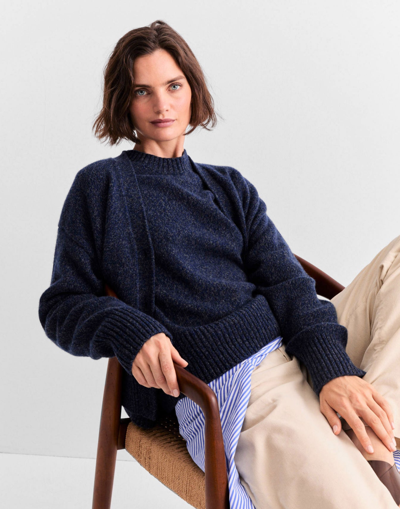 Model leaning back in a chair wearing The Cashmere Raffa - Navy Marl and The Cashmere Tatum - Navy Marl