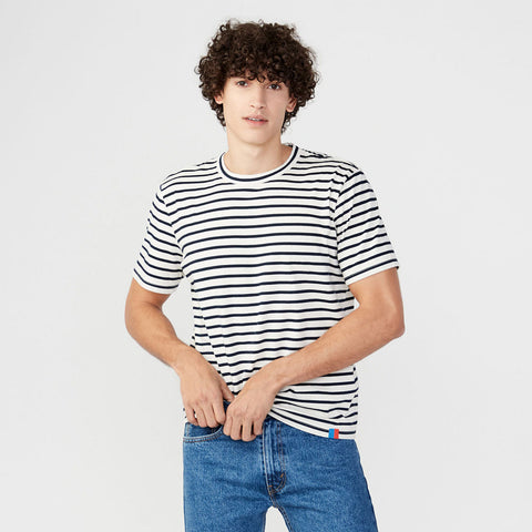 Male model wearing the Archie tee in cream/navy stripes with blue jeans