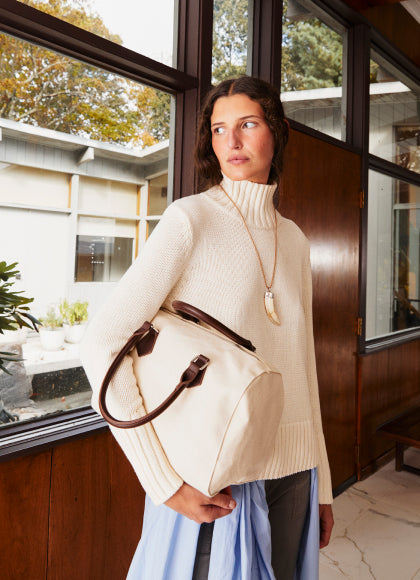 Model wearing The Louis - Cream while holding The Walden - Canvas bag