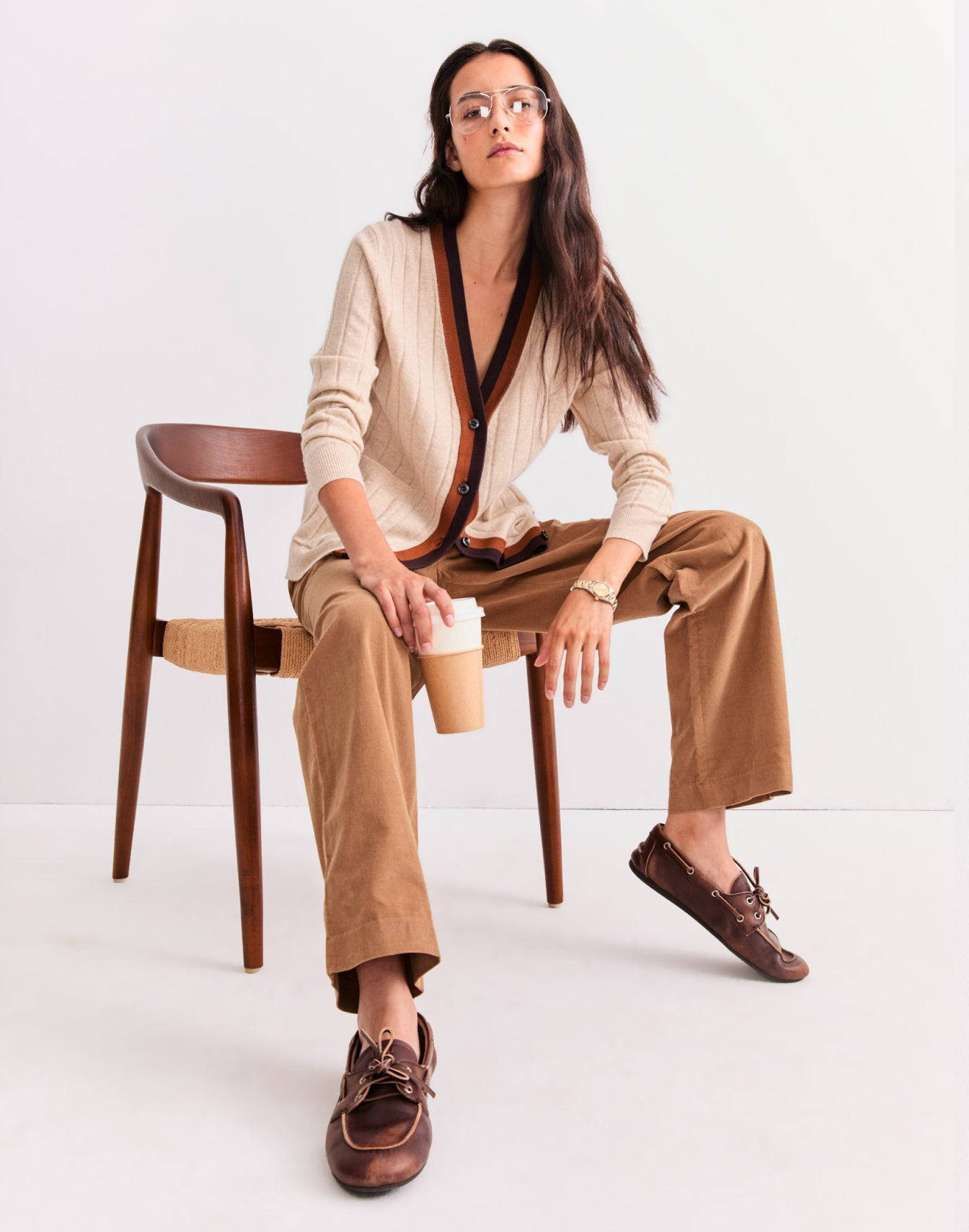 Model sitting in a chair wearing The Sinclair - Oatmeal Melange and holding a coffee cup