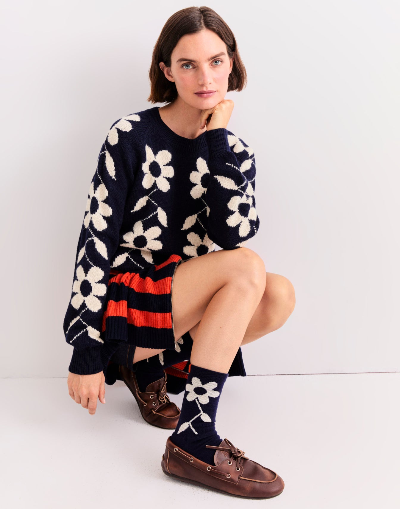 Model crouching down wearing The Franz - Navy, The Bruce - Navy/Poppy, and The Flower Sock - Navy